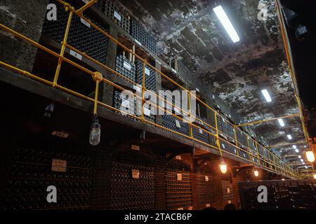 Massandra, Krim - 11. August 2020: Blick auf das Weingut Massandra, dunkler Korridor mit gestapelten Flaschen Stockfoto