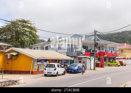 Anse Royale, Seychellen - 18. August 2023: Straßenblick mit Autos und kleinen Geschäften entlang der Straße, Einheimische gehen die Straße entlang Stockfoto