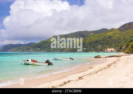 Anse Royale, Seychellen - 18. August 2023: Küstenlandschaft mit Booten vor leerem Strand an einem sonnigen Tag, Fischer in einem Motorboot Stockfoto