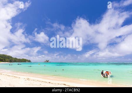 Anse Royale, Seychellen - 18. August 2023: Küstenlandschaft mit leerem Strand an einem sonnigen Tag ist der Fischer in einem Motorboot Stockfoto