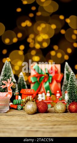 Weihnachtsgeschenkbox Geschenk mit rotem grünem Band auf Holztisch mit Weihnachtsschmuck Dekoration während der Weihnachtsgrüße mit Kopierraum Stockfoto