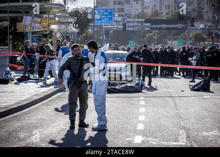 Jerusalem, Israel. November 2023 30. Mitglieder der Internationalen Rettungseinheit ZAKA und israelische Polizeibeamte arbeiten am Ort eines Attentats, bei dem zwei palästinensische Angreifer das Feuer auf Menschen eröffneten, die an einer Bushaltestelle warteten, drei Menschen töteten und mindestens 16 weitere verletzten. Quelle: Stringer/dpa/Alamy Live News Stockfoto