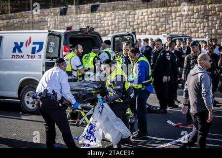 Jerusalem, Israel. November 2023 30. Mitglieder der Internationalen Rettungseinheit ZAKA und israelische Polizeibeamte arbeiten am Ort eines Attentats, bei dem zwei palästinensische Angreifer das Feuer auf Menschen eröffneten, die an einer Bushaltestelle warteten, drei Menschen töteten und mindestens 16 weitere verletzten. Quelle: Stringer/dpa/Alamy Live News Stockfoto