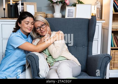 Liebevolle junge Frau Krankenschwester helfen alte Oma während des Hausärztbesuchs, weibliche Hausmeister Arzt sprechen mit älteren Dame geben Empathie Unterstützung PA ermutigen Stockfoto