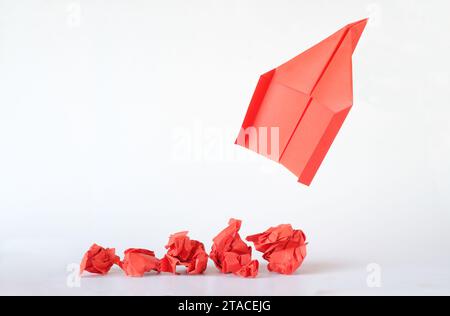 Frische Ideen für das Konzept der Business Transformation mit zerknitterten Papierkugeln und einem Papierflugzeug, das abhebt, Start-up, Erfolg, Teamwork und Kreativität Bus Stockfoto