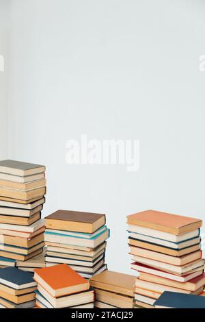 Viele Stapel alter Lehrbücher in der Universitätsbibliothek mit weißem Hintergrund Stockfoto