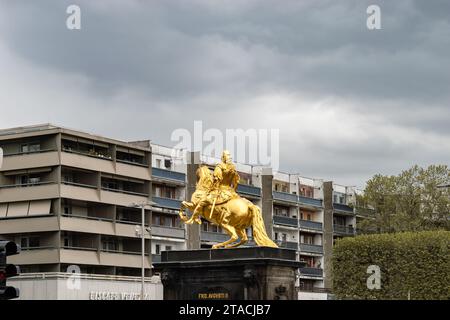 Goldene Reiterstatue vor alten heruntergekommenen Wohnhäusern in einem Wohnviertel. Kulturelle Kontraste in der Neustadt in Dresden. Stockfoto