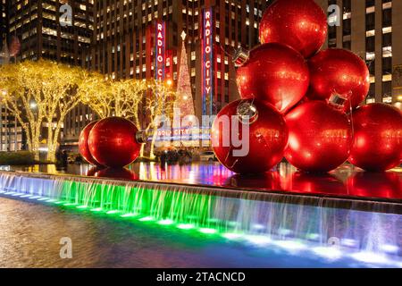 Riesige rote Weihnachtsschmuck auf der 6th Avenue zur Weihnachtszeit von Radio City Music Hall. Midtown Manhattan, New York City Stockfoto