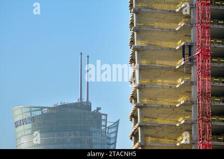 Hochhausgebäude im Bau. Installation von Glasfassadenpaneelen auf einer Stahlbetonkonstruktion. Stockfoto