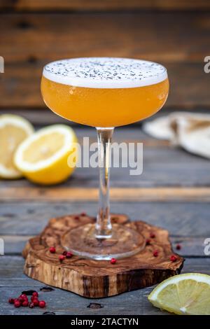 Citric Experience: Erfrischender Cocktail Cup auf einer Olive Tree Coaster - Geschmack und Stil auf einem Holztisch Stockfoto