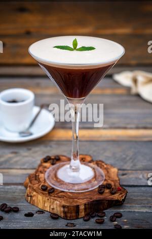 Eleganz in einem Becher: Espresso Martini auf einem Olive Tree Coaster - ein besonderer Geschmack auf einem Holztisch Stockfoto