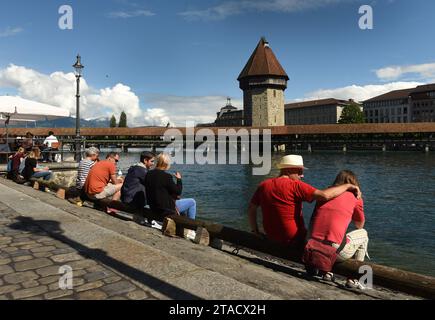 Luzern, Schweiz - 04. Juni 2017: Menschen sitzen auf einem Damm in Luzern mit Kapellbrücke und Wasserturm am Vierwaldstättersee an der Ba Stockfoto