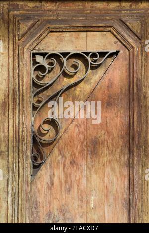 Schmiedeeiserne Ornamente an einer Holztür. Stockfoto
