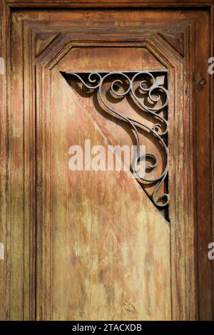Schmiedeeiserne Ornamente an einer Holztür. Stockfoto