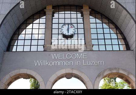 Uhr und Worte 'Willkommen in Luzern' auf dem Bogen vor dem Eingang zum Luzerner Bahnhof, Schweiz. Stockfoto