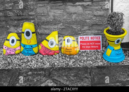 Swanage Minions große bemalte Kieselsteine in Swanage, Dorset, Großbritannien im November - selektive Farbfärbung, Farbspur Stockfoto