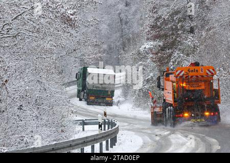 Langenenslingen, Deutschland. November 2023 30. Zwischen Langenenslingen und Friedingen auf der Schwäbischen Alb ist ein winterlicher Straßenräumwagen im Einsatz, während ein Lkw wegen Schneegutscherei auf der Strecke feststeckt Stockfoto