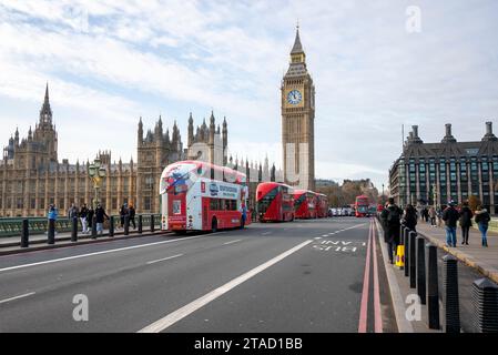 Rote Busse auf der Westminster Bridge mit den Houses of Parliament, London, November 2023 Stockfoto