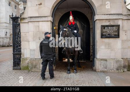 Polizist mit einem King's Life Guard, ein Mitglied der berittenen Household Cavalry, zu Pferd vor der Horse Guards Parade, Whitehall, London Stockfoto