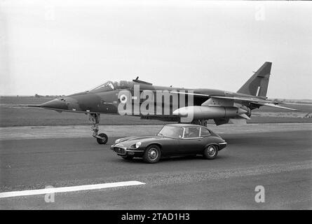 1971 Jaguar E-TYPE Serie 3, V12-Motor, WHP 205J, parkt neben RAF Sepecat Prototyp Jaguar Jagdflugzeug auf der Landebahn Stockfoto