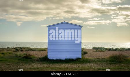 Einzelnes hölzernes Strandhaus an einem Kiesstrand mit Blick auf das Meer. Stockfoto