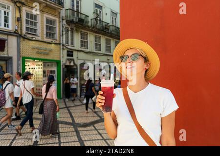 Glückliche Frau trinkt Tee in der schönen Stadt, Coimbra. Stockfoto