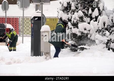 Riga, Lettland. November 2023 30. Die Leute räumen Schnee auf der Straße in Riga, Lettland, 30. November 2023. Quelle: Edijs Palens/Xinhua/Alamy Live News Stockfoto