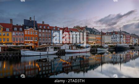 Fischerboote und Weihnachtsdekorationen entlang des Nyhamns-Kanals reflektieren im stillen Wasser, Kopenhagen, 25. November 2023 Stockfoto