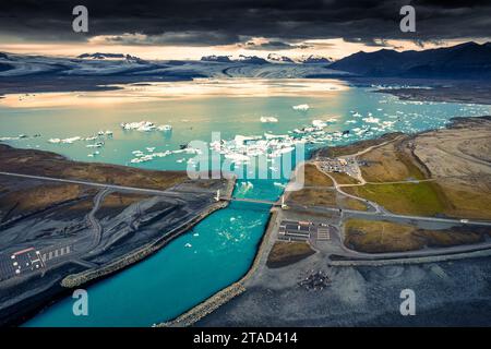Blick aus der Vogelperspektive auf die Gletscherlagune von Jokulsarlon mit schwimmendem Eisberg und die Brücke im Vatnajokull-Nationalpark, Island Stockfoto