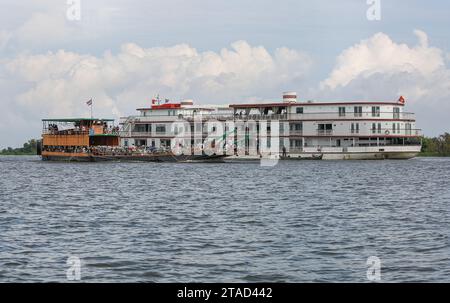 Kambodschanische Fähre transportierte Khmer-Passagiere und Fahrzeuge auf dem Tonle SAP Fluss in der Nähe des luxuriösen Mekong Kreuzfahrtschiffs Jahan (Heritage Line), Kambodscha, Asien Stockfoto