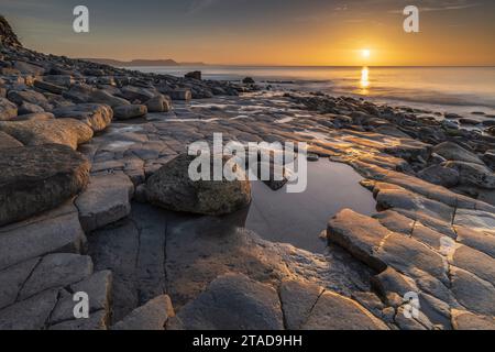 Sonnenaufgang über der Lyme Bay vom Ammonitenpflaster, Lyme Regis, Dorset, England. Winter (Februar) 2022. Stockfoto