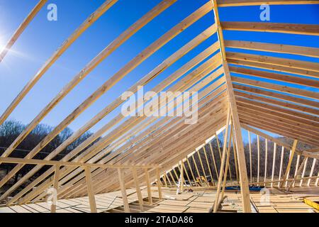 Das Dach des neuen Hauses wird mit Traversen gebaut, die von Holzbalken gestützt werden Stockfoto