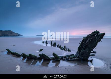 Sonnenuntergang über dem Schiffswrack der Helvatia in Rhossili Bay, Gower, Südwales, Großbritannien. Frühjahr (März) 2022. Stockfoto