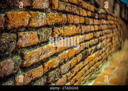 Nahperspektive einer alten verwitterten Backsteinmauer an einer historischen Ruine mit detaillierten orangefarbenen und braunen Mauerwerk-Texturen. Stockfoto