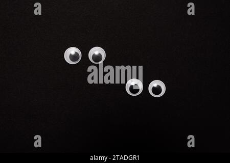 Paar lustige, geile Augen auf schwarzem Hintergrund mit Kopierraum Stockfoto