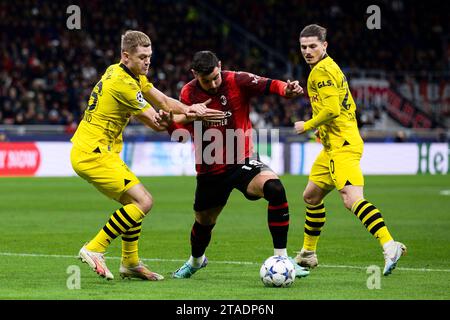 Mailand, Italien. 28. November 2023. Theo Hernandez vom AC Mailand tritt beim Fußball-Spiel der Serie A zwischen AC Mailand und Borussia Dortmund gegen Julian Ryerson und Marcel Sabitzer von Borussia Dortmund um den Ball an. Quelle: Nicolò Campo/Alamy Live News Stockfoto