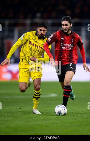 Mailand, Italien. 28. November 2023. Yacine Adli vom AC Milan tritt beim Fußball-Spiel der Serie A zwischen AC Milan und Borussia Dortmund mit Emre Can von Borussia Dortmund um den Ball an. Quelle: Nicolò Campo/Alamy Live News Stockfoto