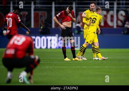 Mailand, Italien. 28. November 2023. Mats Hummels von Borussia Dortmund feiert den Sieg mit Julian Ryerson von Borussia Dortmund, als Olivier Giroud vom AC Milan am Ende des Serie A Fußballspiels zwischen AC Milan und Borussia Dortmund niedergeschlagen aussieht. Quelle: Nicolò Campo/Alamy Live News Stockfoto