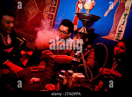 Ein junger vietnamesischer Mann raucht eine Shisha in der Dragonfly Bar in Hanoi, Vietnam Stockfoto