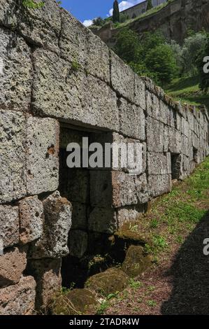 Eine Reihe etruskischer Würfel- oder Kammergräber in der etruskischen Grabstätte von Crocifisso del Tufo in Orvieto, Umbrien, Italien. Die Nekropole befindet sich auf der Nordseite von Orvieto, direkt unterhalb der Tuffsteinklippe, auf der die Stadt thront. Stockfoto