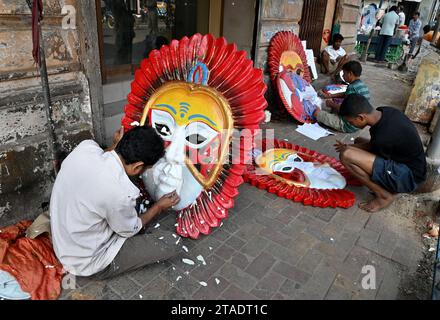 Der Künstler stellt Thermokolmasken in verschiedenen Farben in den Straßen von Kalkutta her. In Westbengalen in Indien. Stockfoto