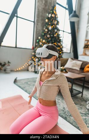 Mit einem Virtual-Reality-Headset führt der Yoga-Coach während der Silvesterferien Online-Sitzungen durch. Stockfoto