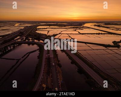 Eine Luftaufnahme des pulsierenden Sonnenuntergangs über den Salinas de Aveiro, den Salinen Portugals Stockfoto