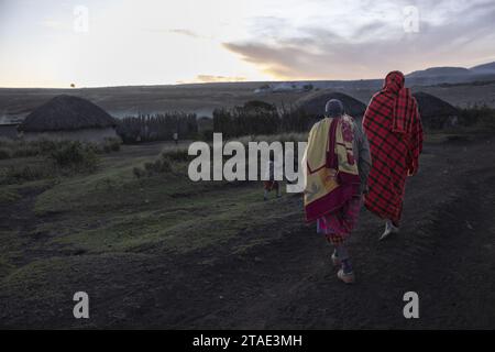 Tansania, Region Arusha, Malanja, das Dorf bei Sonnenuntergang kehren zwei Massai in das Dorf zurück, bevor die Nacht einbricht Stockfoto