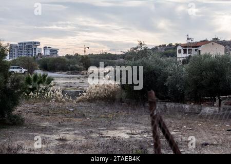 Nikosia, Nikosia, Zypern. November 2023 30. Das Haus von Christalla und ein UN-Fahrzeug sind in der Pufferzone mit Nikosia-Gebäuden im Hintergrund zu sehen. Die türkische Armee installierte vor zwei Tagen eine Kamera und die Flaggen der Türkei und der so genannten "Türkischen Republik Nordzypern" auf dem Dach eines verlassenen Hauses, bekannt als "Haus von Christalla", innerhalb der UN-Pufferzone. das offiziell das Gebiet der Republik Zypern ist, das der UNO aus friedenserhaltenden Gründen freiwillig zur Verfügung gestellt wird. Da es sich bei diesem Akt um ein Eindringen in den Pufferzone-Status quo handelt, forderte die Republik Zypern die UNO-Truppen auf Stockfoto