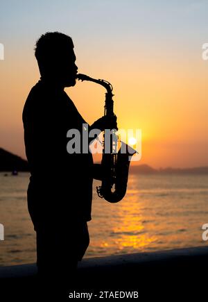 Musiker, der bei Sonnenuntergang Saxophon spielt Stockfoto