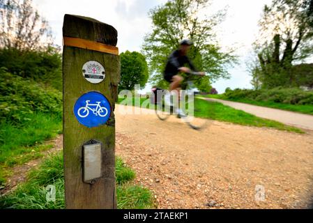 Ein Mann radelt auf einem der Schotterwege in Hampstead Heath im Norden Londons Stockfoto