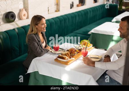 Ein junges Paar beim Mittagessen und beim Trinken von frisch gepresstem Saft im Restaurant Stockfoto