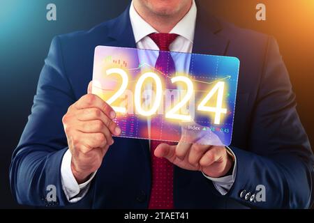 Geschäftsmann, der mit der Technologie der Zukunft arbeitet, neues Jahr 2024 Finanzkonzept. Stockfoto