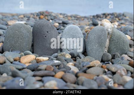 Fünf Felsen an einem felsigen Strand. Glatte Kieselsteine. Stockfoto